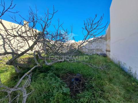 Terreno urbano com construção antiga no centro de quarteira