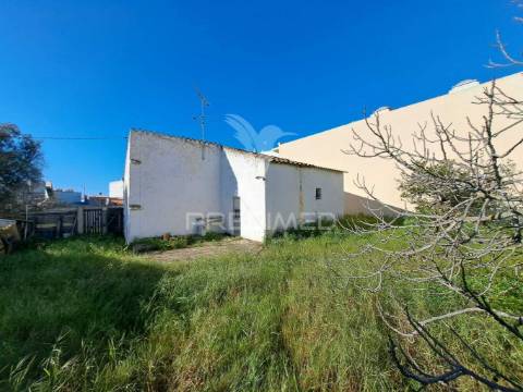 Terreno urbano com construção antiga no centro de quarteira