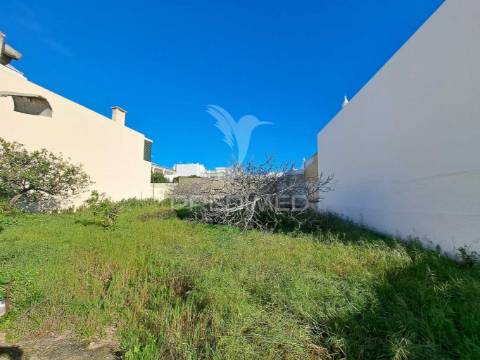 Terreno urbano com construção antiga no centro de quarteira