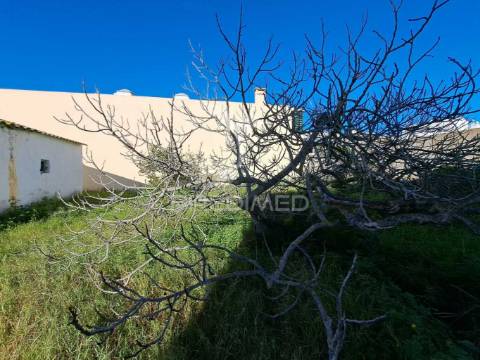 Terreno urbano com construção antiga no centro de quarteira