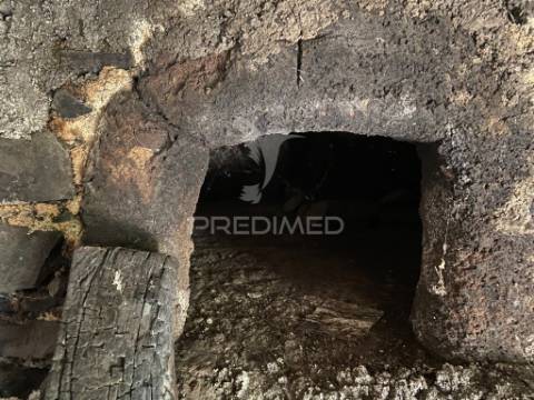 Moradia e palheiro em pedra com 2.770m2 de terreno no arco da calheta